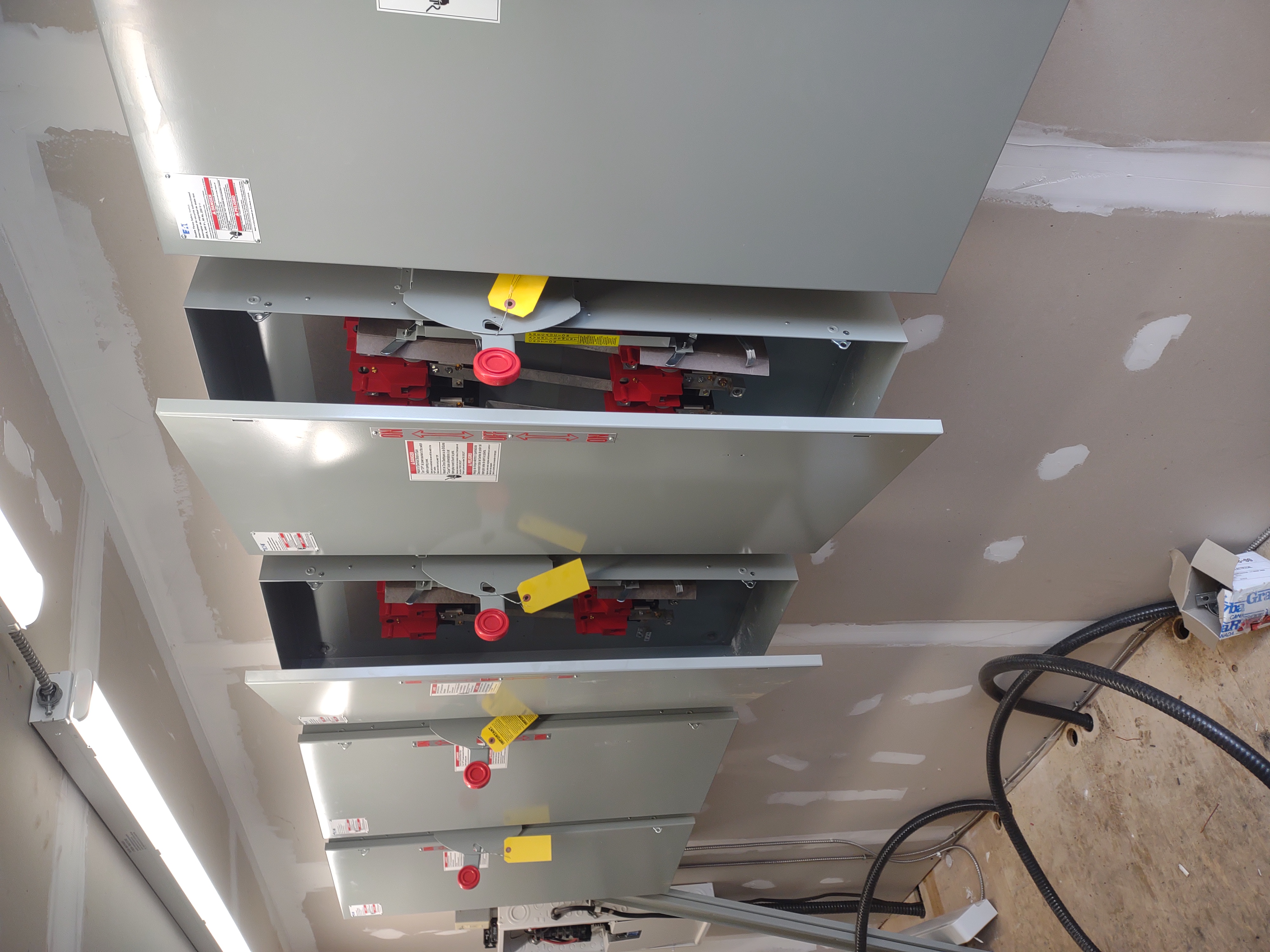 Commercial electrical room with installed disconnect panels and organized infrastructure work in progress